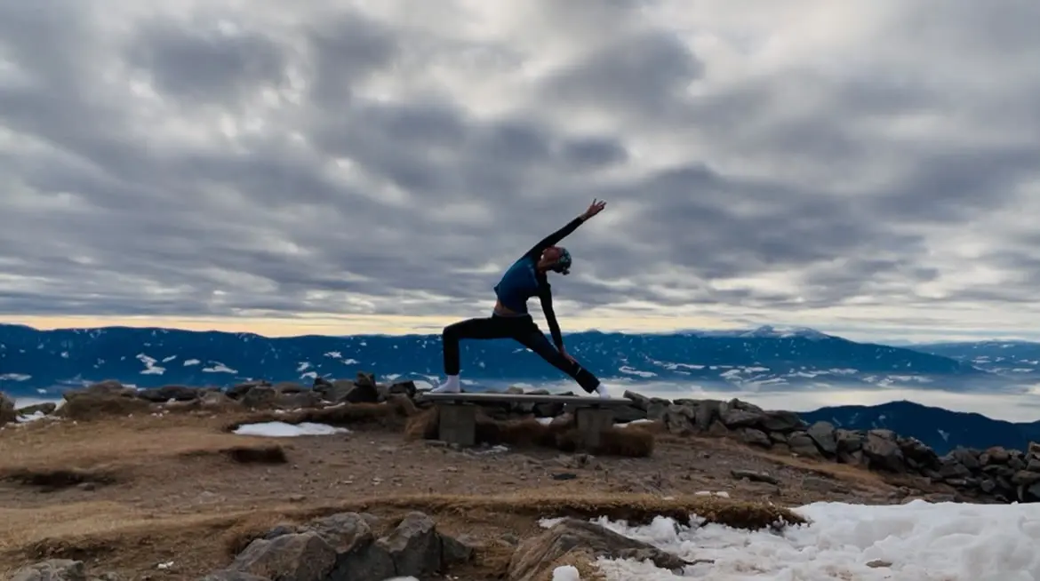 Daniela Schimpl in einer Yoga-Pose vor einem weiten Bergpanorama