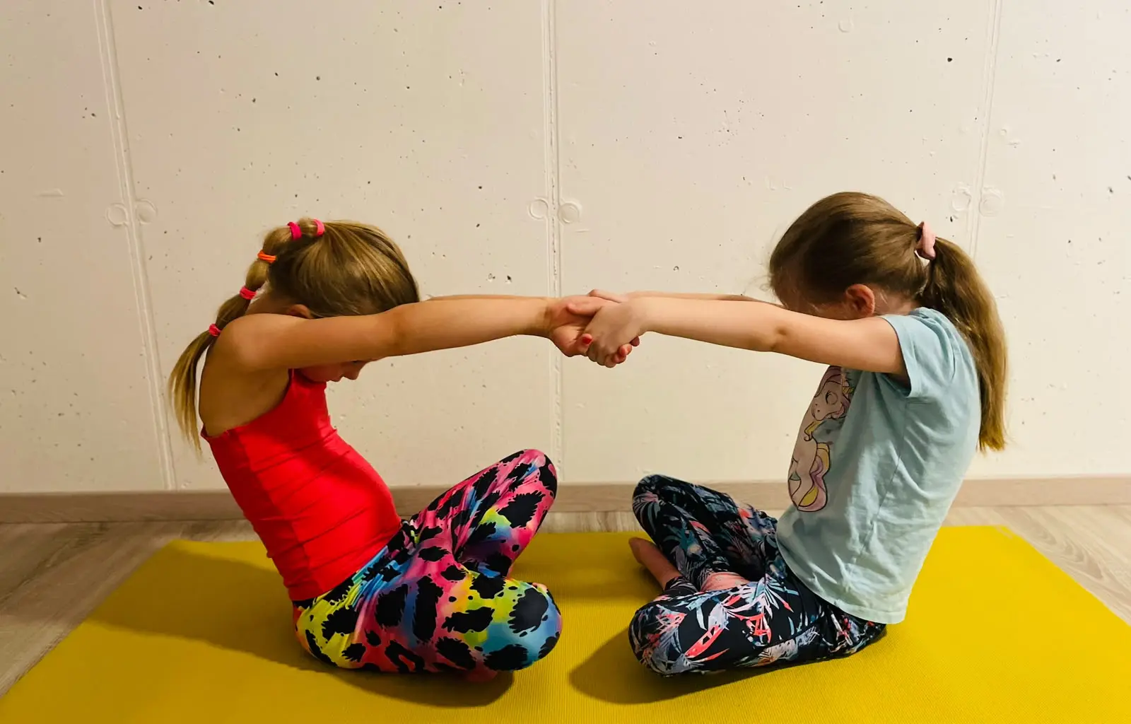 Zwei Mädchen bei einer Partnerübung im Kinder-Yoga